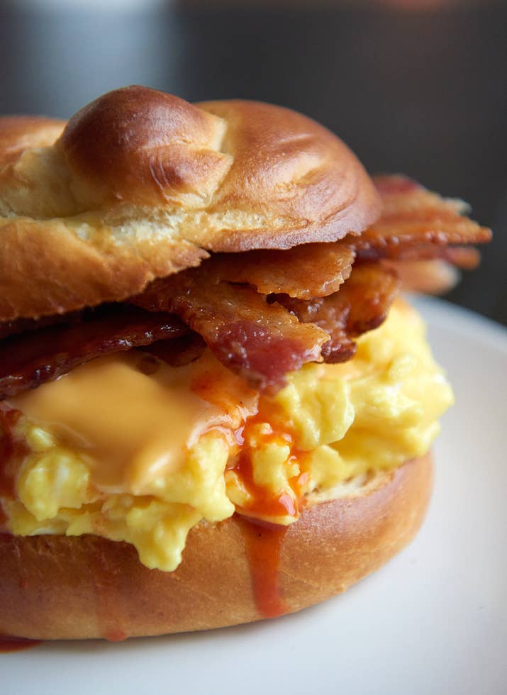 Pile your scrambled eggs high and proud on a toasted kaiser roll or English muffin, top the eggs with a slice of *American Cheese*, some crispy bacon and too much hot sauce.