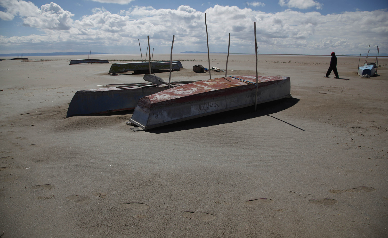 A fisherman walks along the abandoned boats in the dried-up Lake Poopo.
