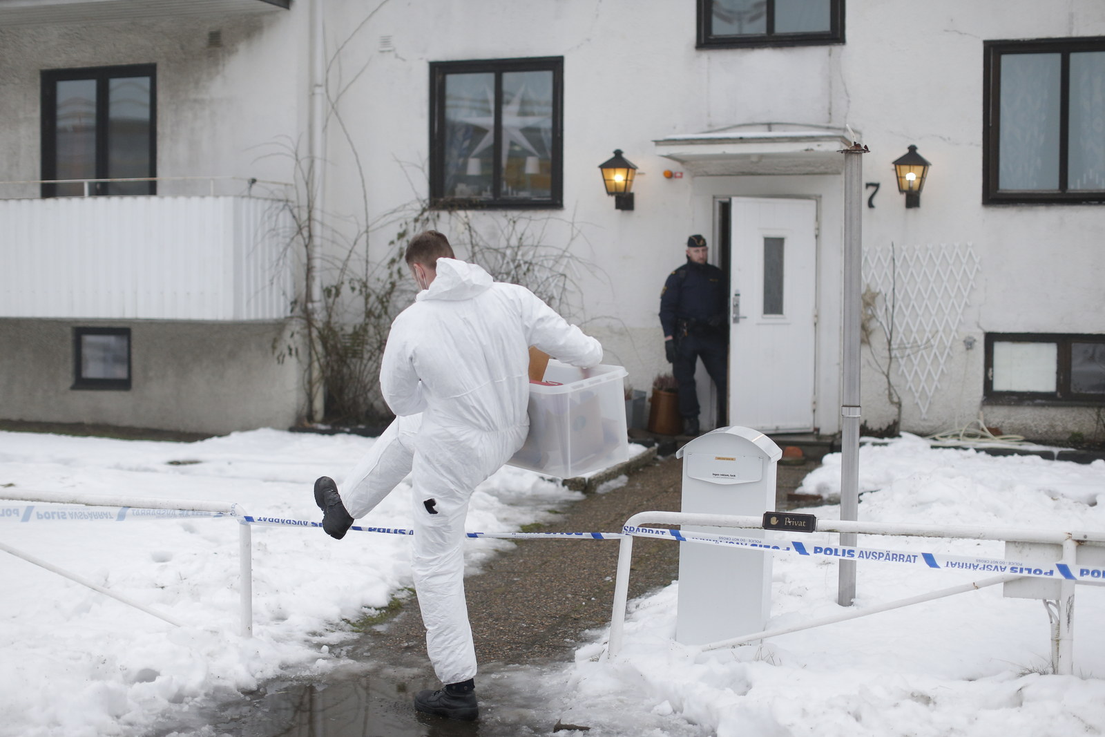 A forensic police officer carries a box of evidence at the migrant center in Molndal, Jan. 25.