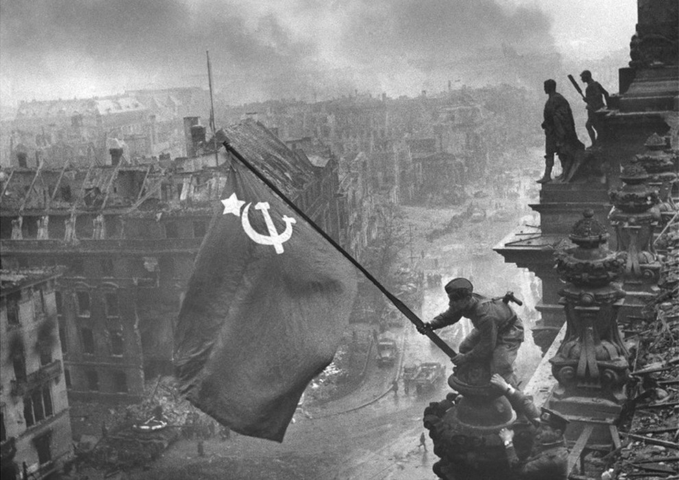 Soldados del Red Army izando una bandera de la hoz y el martillo sobre Reichstag en Berlín, 1945.
