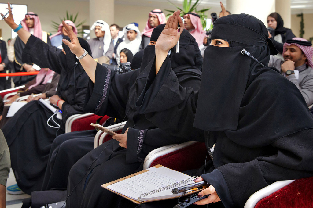 Female Saudi journalists raise their hands to ask questions as U.S. Secretary of State John Kerry and Saudi Foreign Minister Adel al-Jubeir speak to members of the media at the King Salman Regional Air Base in Riyadh, Saudi Arabia.