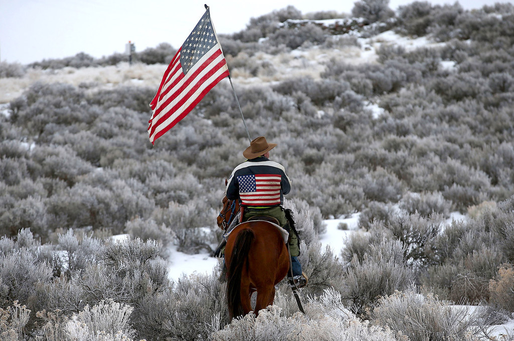 Dwayne Ehmer carries an American flag as he rides his horse on the Malheur National Wildlife Refuge near Burns, Oregon. An armed anti-government militia group continues to occupy the Malheur National Wildlife Headquarters as they protest the jailing of two ranchers for arson.