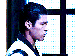 a man looks over his shoulder at a woman, who nods back