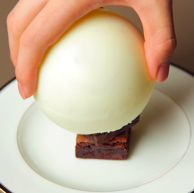 Gently place the chocolate bomb over the stack: