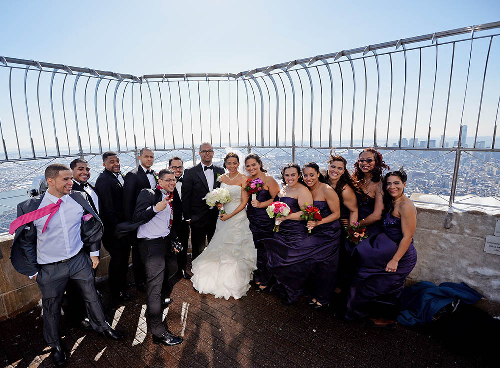 Bride Veronica Vizcaino and groom Gustavo Espinal pose with their wedding party on the 86th Floor Observatory of the Empire State Building in New York City, 2014. The only day that couples are able to marry at the Empire State Building is on Valentine's Day.