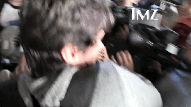 The clip shows Yeezy navigating a media frenzy when one photographer throws a punch at the guy next to him.