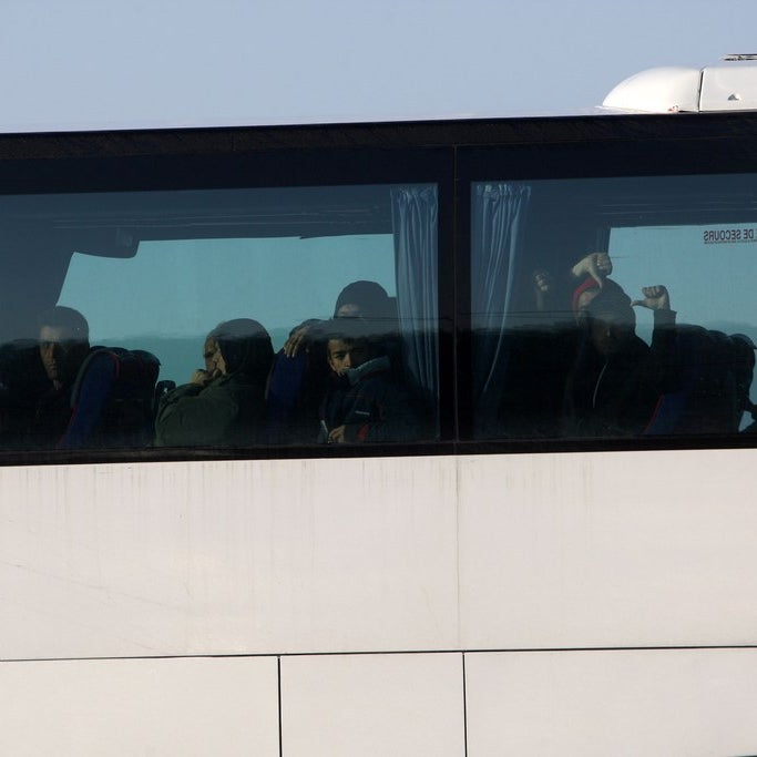 Refugees loaded on a bus by police at Idomeni in Greece