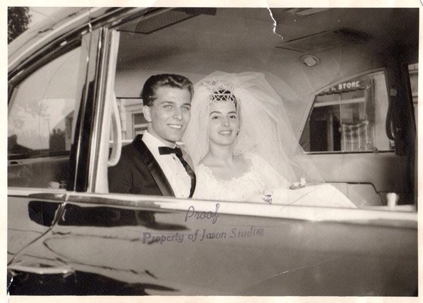 An old wedding photo of the married couple in an old car