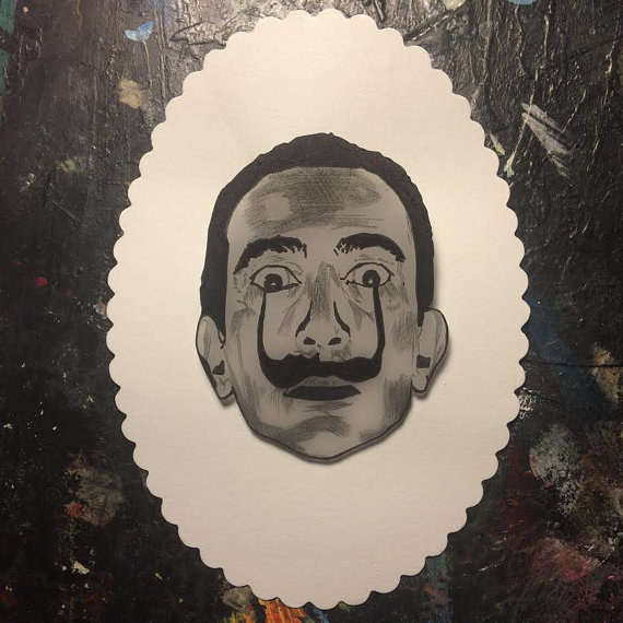 Dale un toque artista, locuaz y divertido a tu look con este broche de Dalí.Cómpralo aquí.