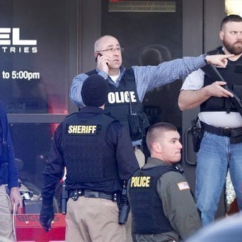 Police guard the front door of Excel Industries after the shooting in Hesston, Kansas.