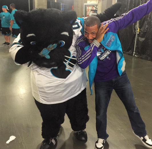 Sir Purr, the Carolina Panthers' mascot leads the Harris YMCA flag