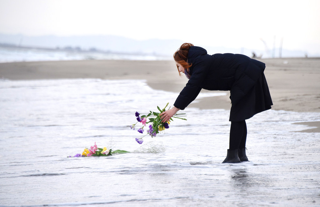 A woman puts flowers into the sea to pray for victims of the 2011 earthquake and tsunami in Sendai, northern Japan. Japan marked the fifth anniversary of the March 11th quake and tsunami that claimed some 18,500 lives, flattened coastal communities and set off the worst atomic crisis in a generation.