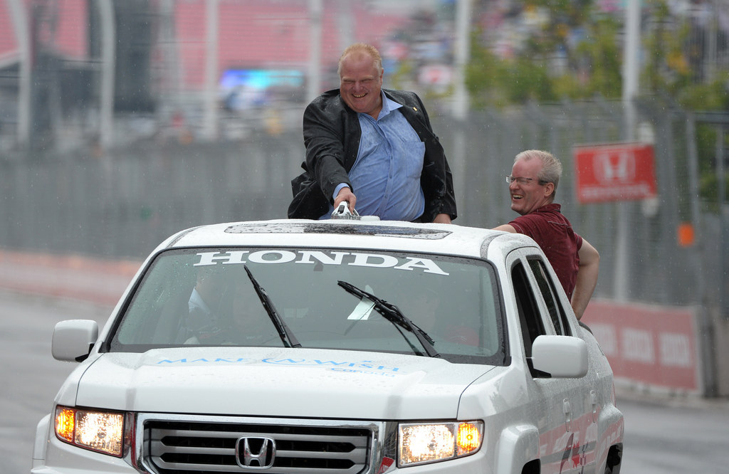 Rob Ford going on a joyride ontop of a car at the Verizon IndyCar Series Honda Indy in Toronto.