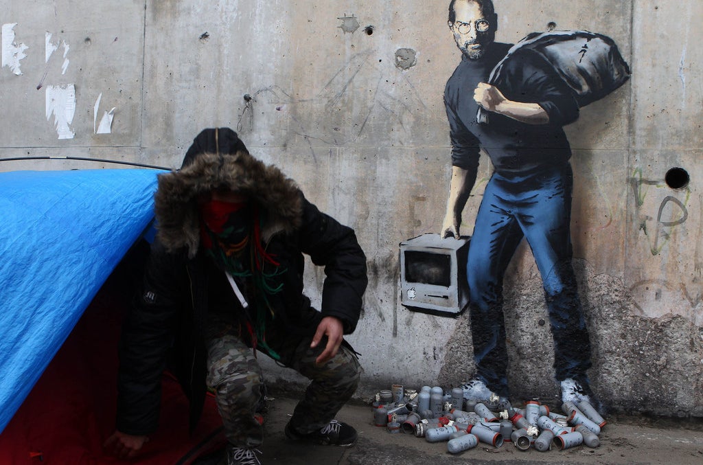Una pintura de Banksy afuera del campamento de refugiados Calais en Francia.
