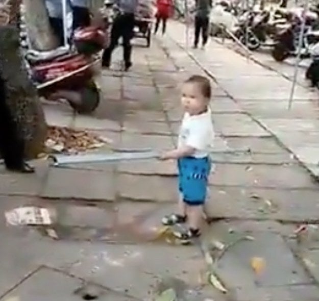 In the video, the unnamed boy approaches a group of Chengguan in a marketplace. The Chengguan are urban management and code enforcers in China. The grandmother's setup was allegedly taking up too much sidewalk space.