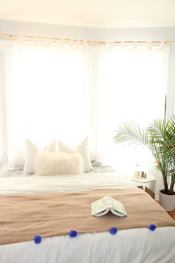 You can get a similar blanket for $20 here, and get the tutorial to make the pom-poms here.