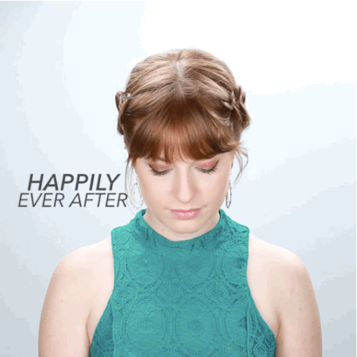 Part hair down the middle and start a french braid on one side down to the back of the nape. Do the same on the other side. Spray with hairspray and pull out the side of the braid to make it look fuller. Take the two braids in the back and wrap them together to form a bun-type shape and pin.