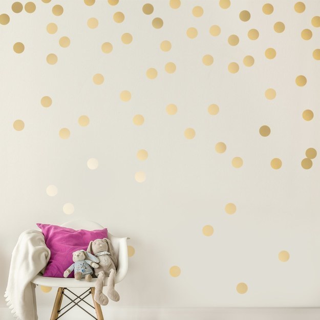 Gold polka-dot wall decals that'll safely peel away from your wall.