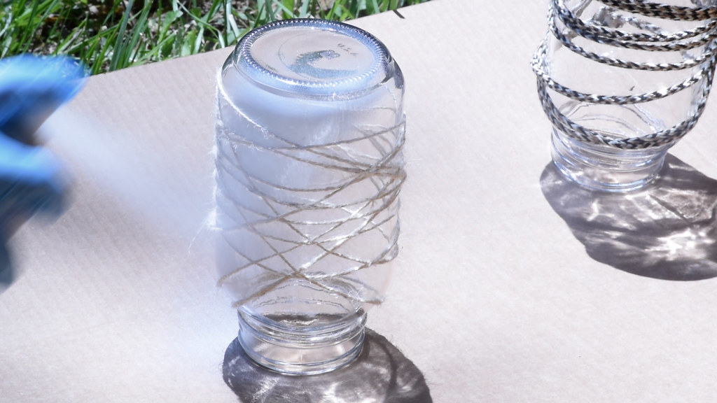 In a well ventilated area cover the jars in spray paint. Apply at least two coats, allow the paint to dry between coats. Once dry cut the yarn free and peel off.