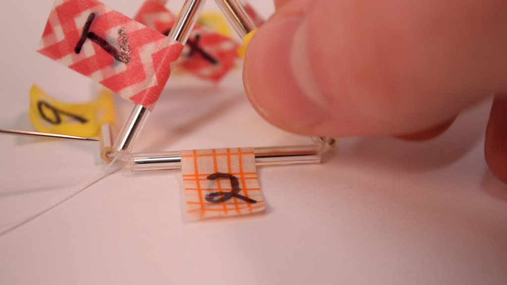 Thread through 2 and the rest of the beads that make the bottom of the pyramid; 5, 8, and 6.
