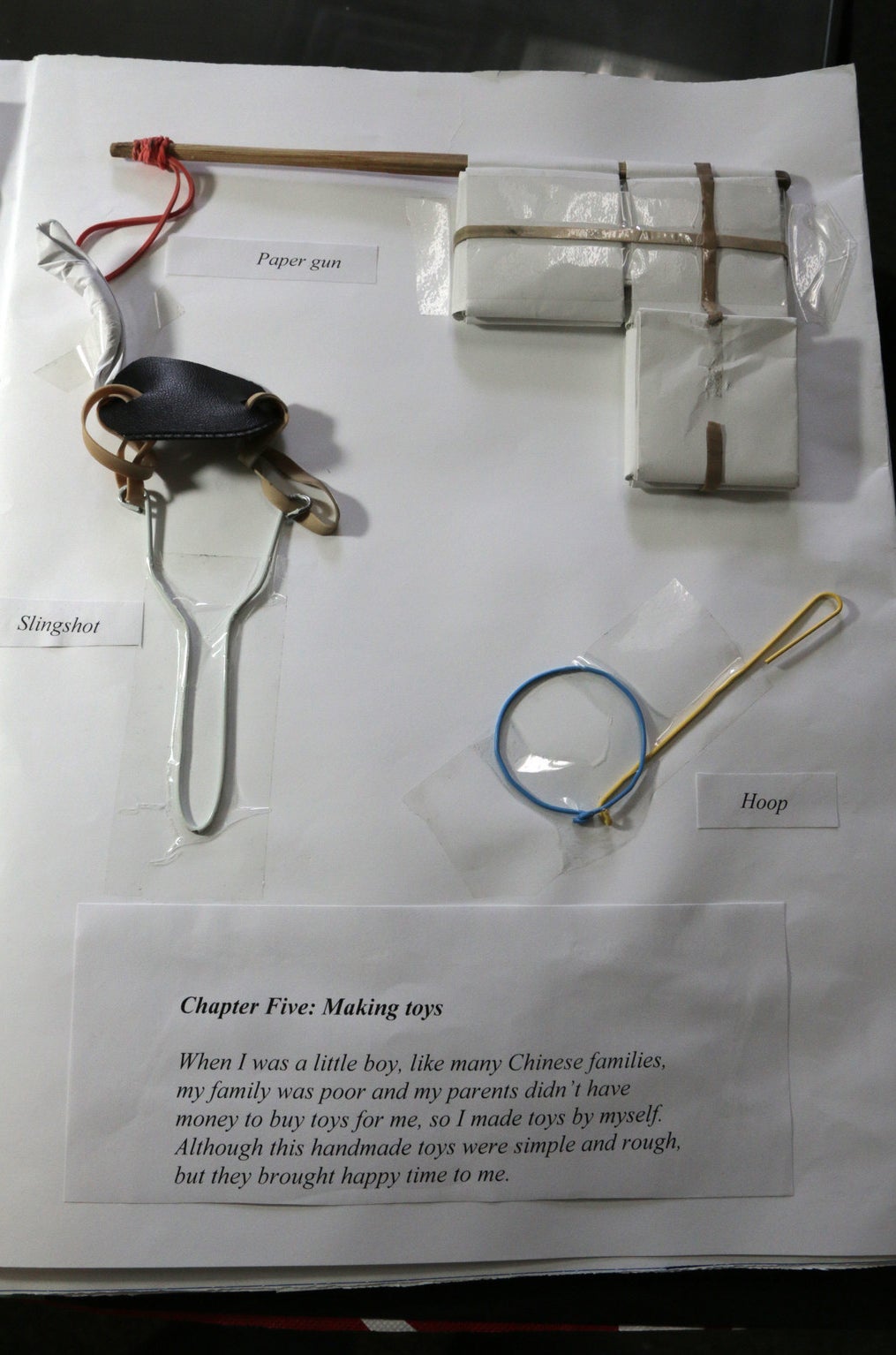 Paper gun, slingshot, and hoop, some of the few toys children had at that time, presented in Wang's photo book.