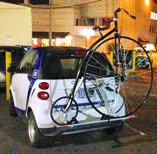 Este velocípedo en la parte trasera de un carro marca Smart.