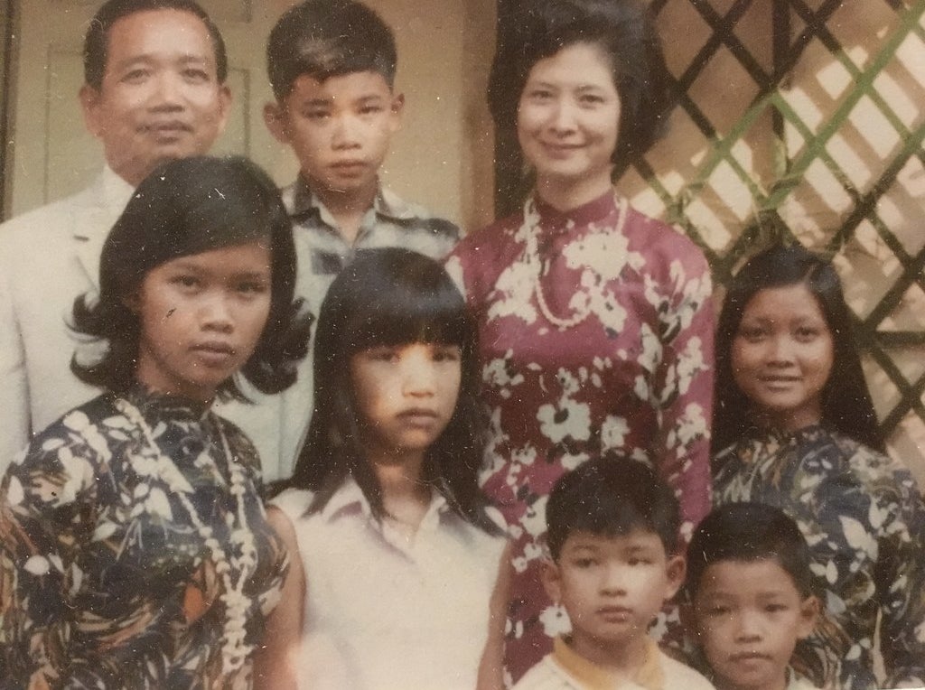 A family portrait (including my father, yellow collar, bottom right) at their home in the the city formerly known as Saigon, in 1968.