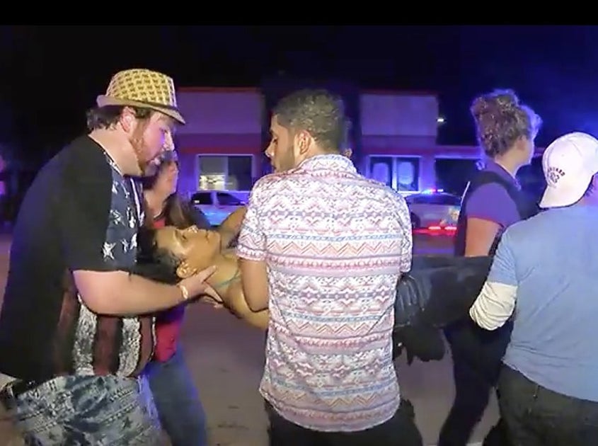 Christopher Hansen (left) helping others carry an injured woman outside Pulse.