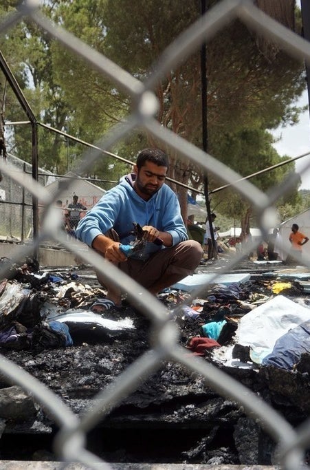 Refugees survey the damage after a riot.