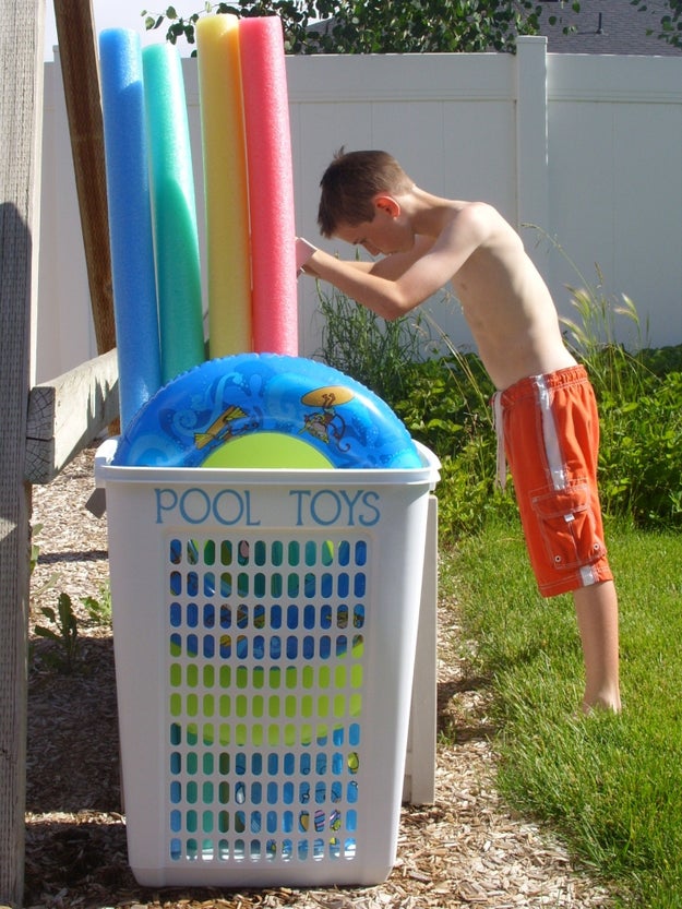 Use a big laundry hamper to corral oversized pool toys.