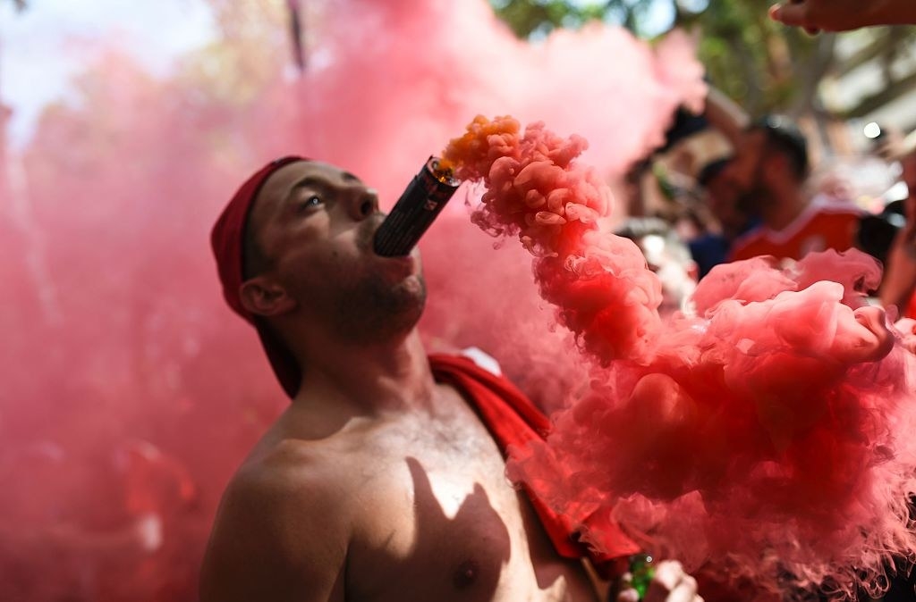 A Wales supporter celebrates with a flare in his mouth ahead of the match against Russia.