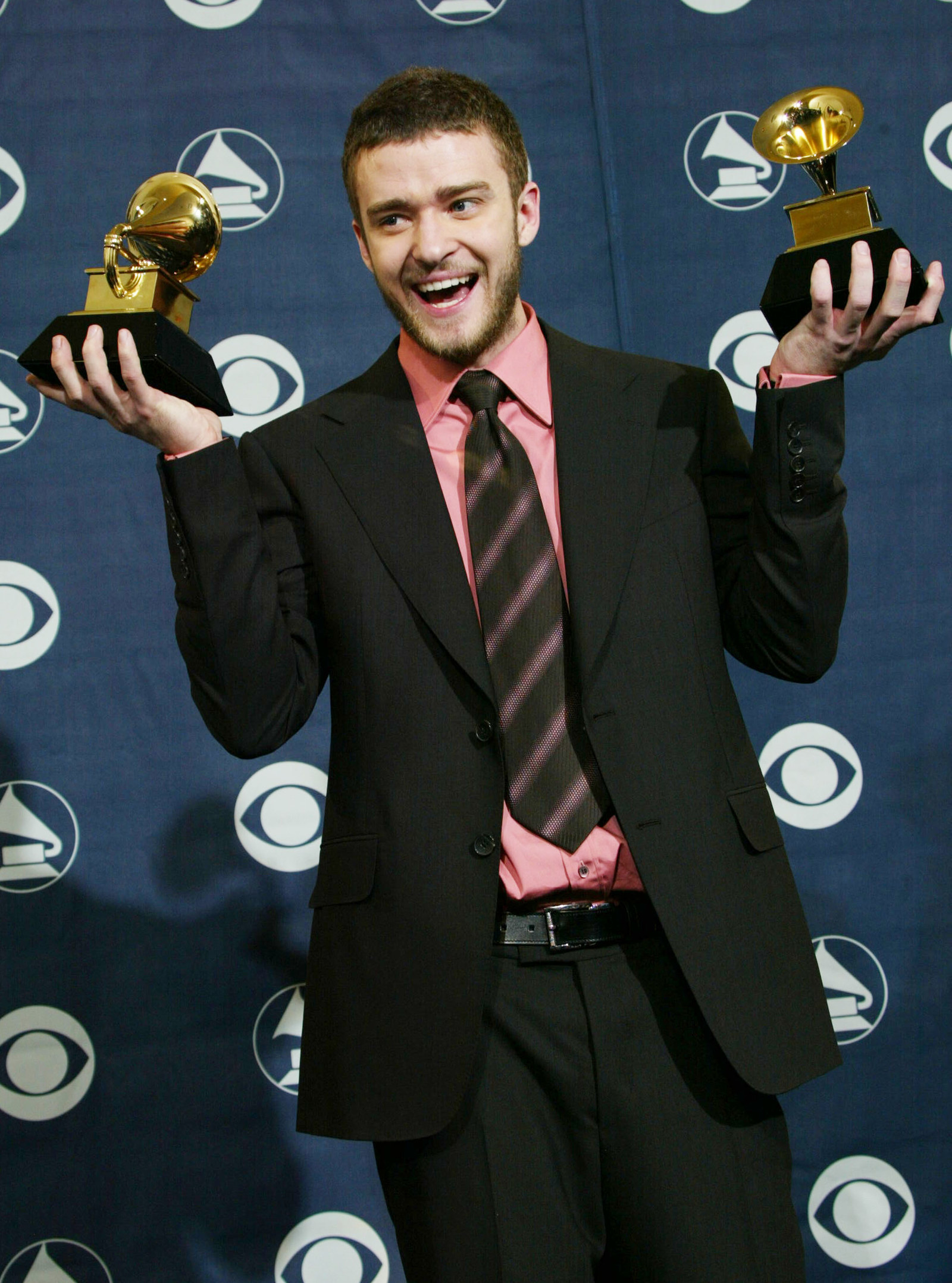 Justin Timberlake holding two Grammy awards he won