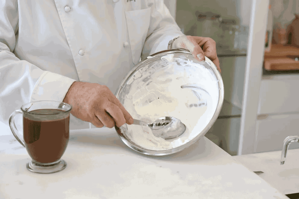 Pour faire une quenelle, plongez une cuillère bien chaude et sèche dans la crème fouettée et donnez-lui la forme d'un ballon de rugby un peu arrondi.