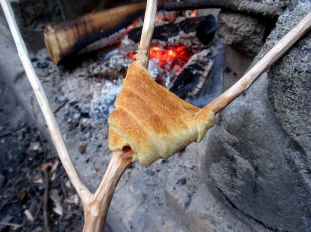 Prepare crescent rolls over the campfire.