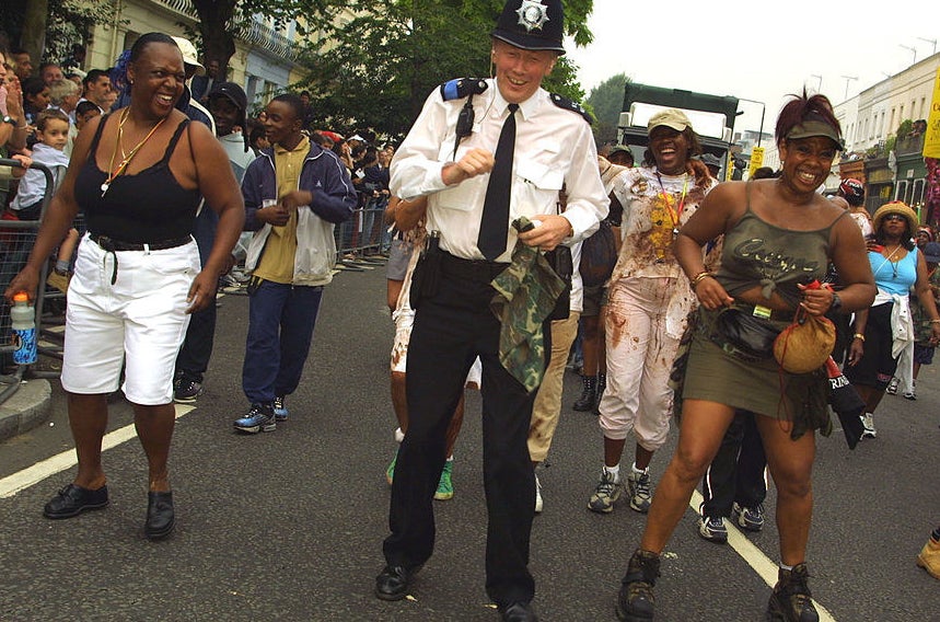 London Police Constable Ray Jack dances in the street with revellers August 26, 2001