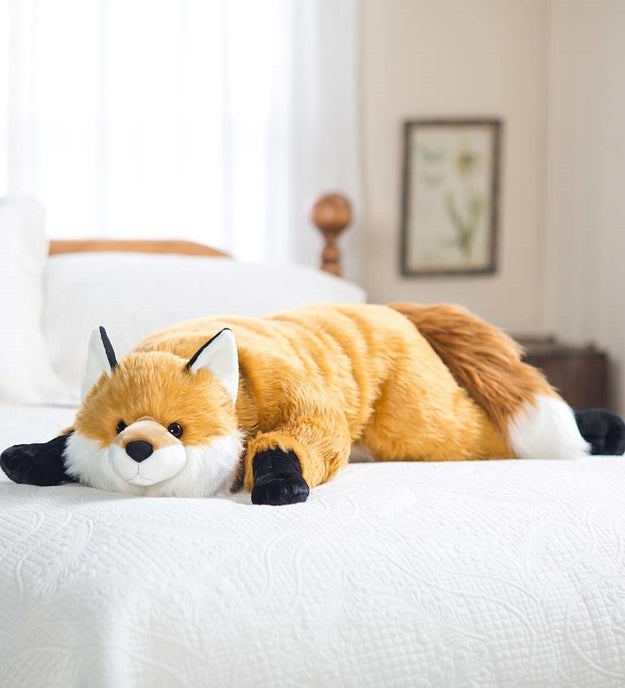 A body pillow shaped like an enormous fox.