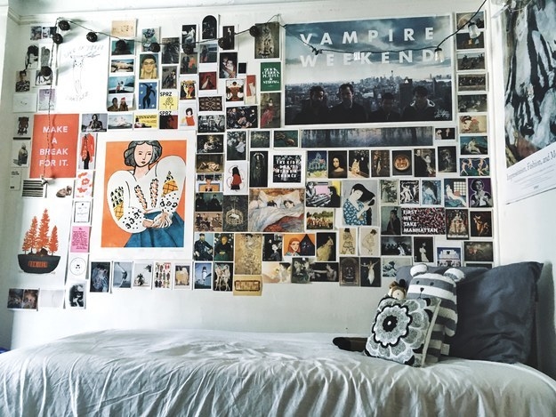 A wall above a twin bed covered in photos and posters of different sizes