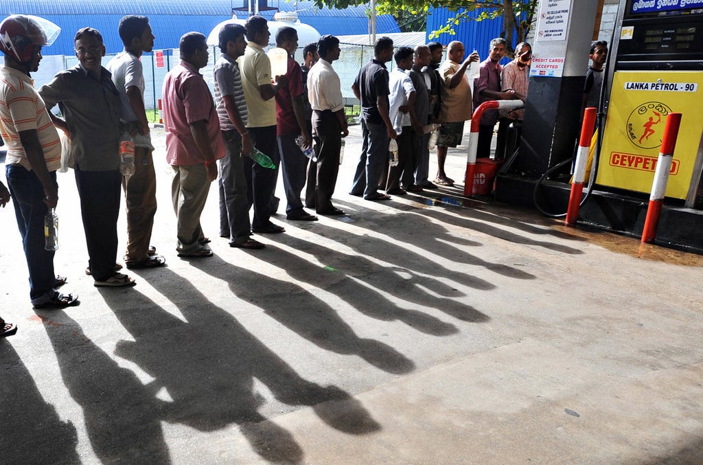 Sri Lankans, holding plastic bottles, wait in line to buy petrol in 2008 during a fuel shortage.