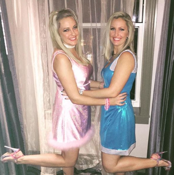Two people in sparkly pink and blue Barbie dresses