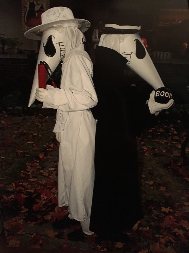 Two people in costumes with masks on their faces