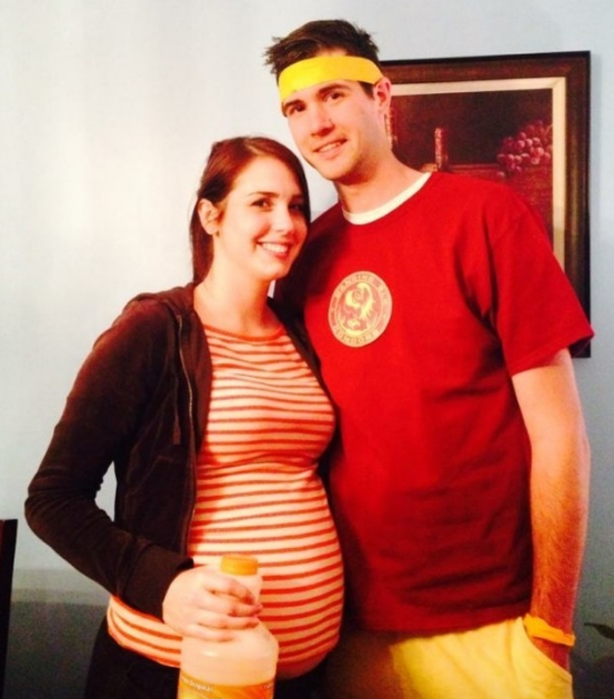 A pregnant woman in a striped shirt and a man in a red shirt with a sweatband