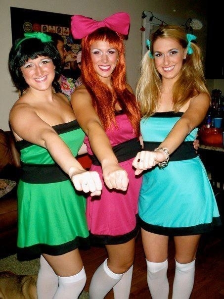Three women in colorful short dresses and hair bows