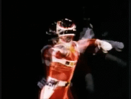 a power ranger uses a sword to knock a large vial of liquid with a head inside 