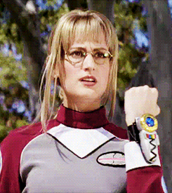 the same girl as above points at her wrist and wears a power rangers suit