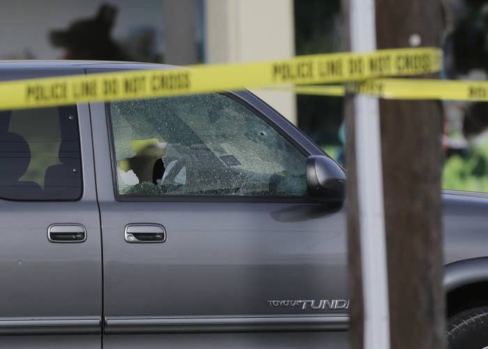 A car's windows are shattered by bullets at the scene of a shooting in Houston.