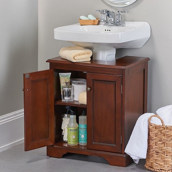 Find a happy medium between a pedestal sink and vanity by fitting a specially designed cabinet around the sink base.