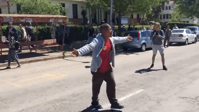 "Are you going to shoot me for crossing the road?" one of the protesters asks the police as he crosses the street away from campus. "You do not know our pain, our families' pain!" he yelled at the bystanders on the other side of the median.