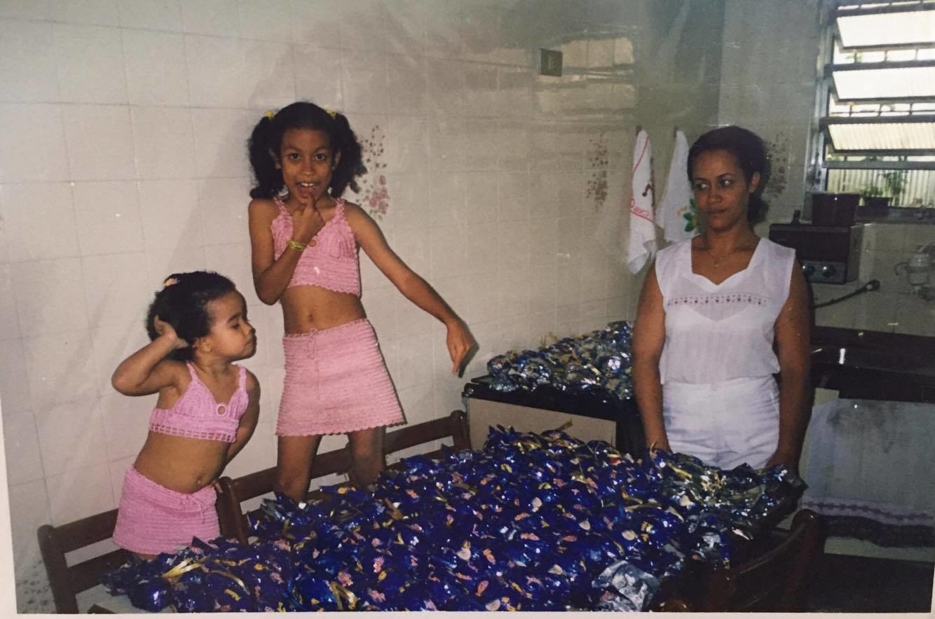 "Nessa foto eu tinha quatro anos e minha irmã nove. Todo ano meu pai doava ovos de Páscoa para crianças carentes (o que explica a ostentação na mesa). Acho que a foto fala por si só, ou no caso a doce expressão de: 'tenha filhos, eles disseram' estampada no rosto da minha mãe!" – Fernanda Vieira