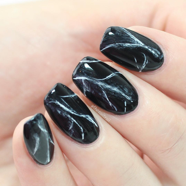 With a touch of white polish mixed in, you can achieve an elegant and fashionable black marble look.