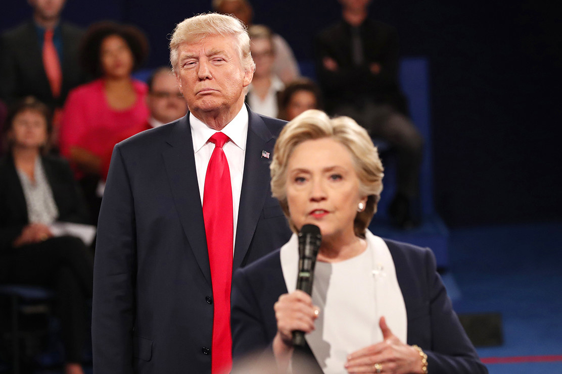Republican U.S. presidential nominee Donald Trump listens as Democratic nominee Hillary Clinton answer a question from the audience during their presidential town hall debate at Washington University in St. Louis, Missouri, on October 9, 2016.